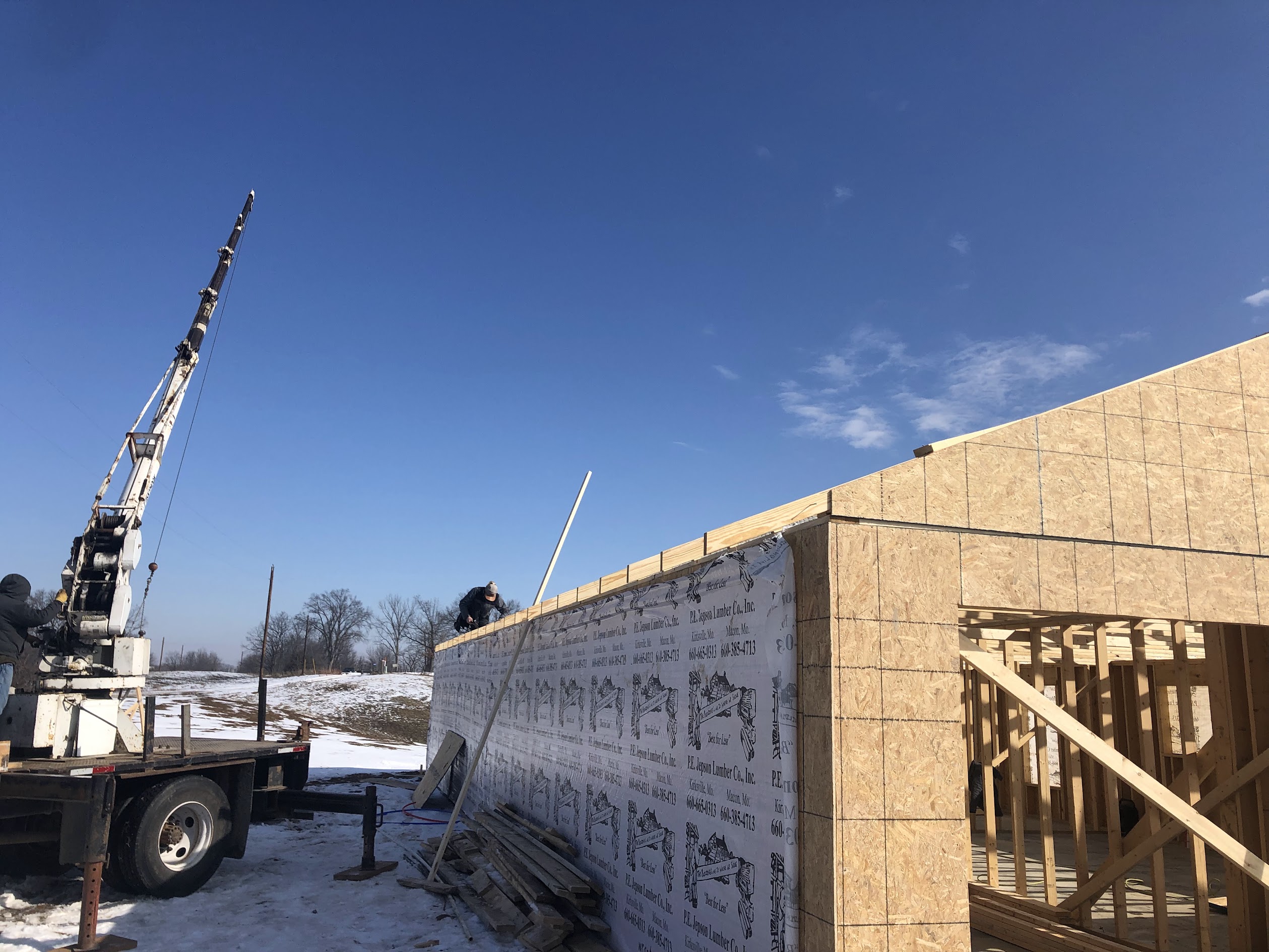 New construction framing with crane in winter